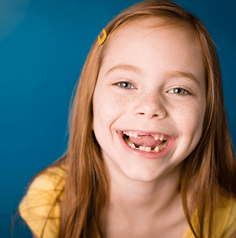young girl with no front teeth smiling